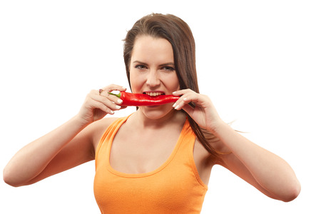 fun woman biting sweet pepper isolated on whiteの写真素材