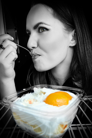 woman eats night dessert in refrigeratorの写真素材
