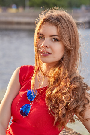 woman in red dress near river posingの写真素材