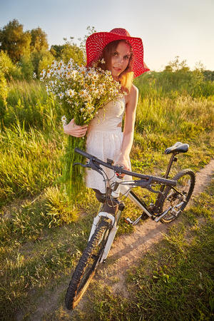 pretty woman with bouquet and bikeの写真素材