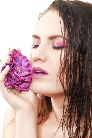 sensual woman with wet hairs and purple flower isolated on whiteの写真素材