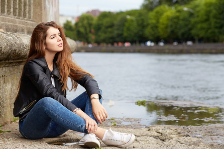 pensive woman in leather jacket portraitの写真素材