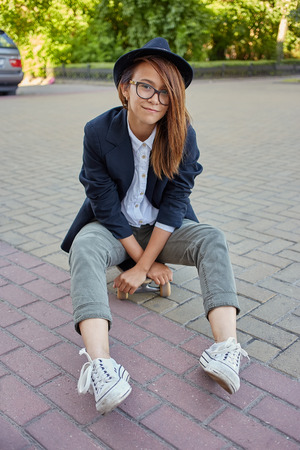 smiling girl hipster sitting on skateboardの写真素材