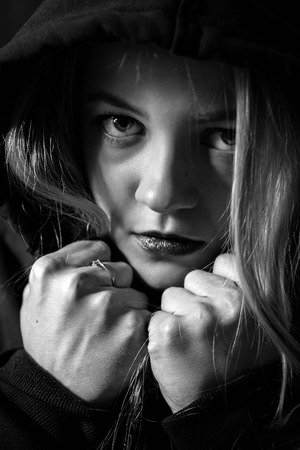 dramatic portrait of serious girl in the darkの写真素材