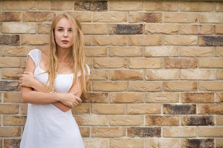 sensual blond young woman near yellow bricks wall, image with copyspaceの写真素材