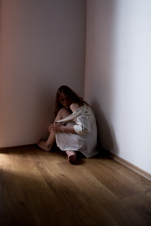 scared girl in cornerの写真素材