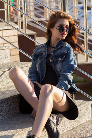 Portrait of a happy woman sitting on stepsの写真素材