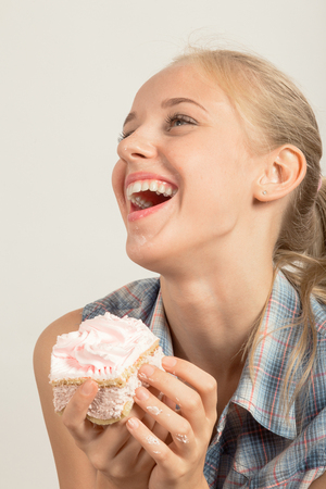 fun happy girl with sponge cake on white backgroundの写真素材