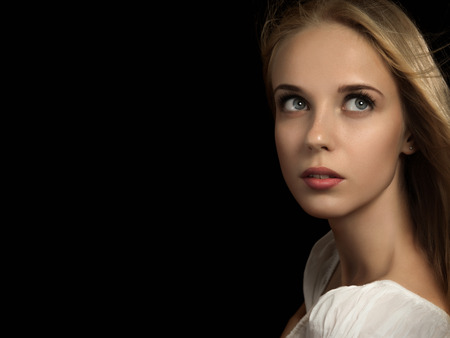luxury scared blond girl on black background with copyspaceの写真素材
