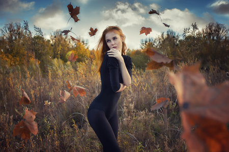 sensual girl posing inside flying leavesの写真素材