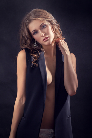 beautiful sensual woman with curly hair on black backgroundの写真素材