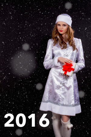 Attractive Young Miss Santa Posing on White Background with snowの写真素材