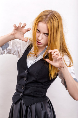 serious girl with yellow hair in attack pose on white backgroundの写真素材