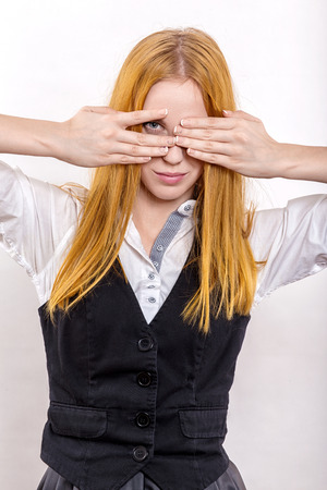 fun girl with yellow hair cover her face on white backgroundの写真素材