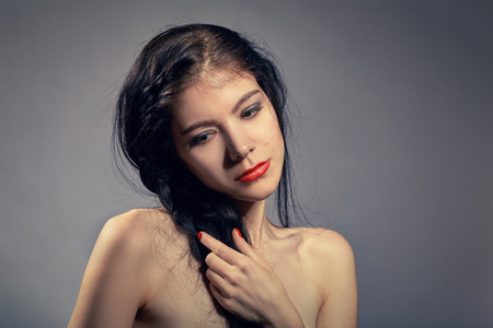 attractive girl with black plait on gray backgroundの写真素材