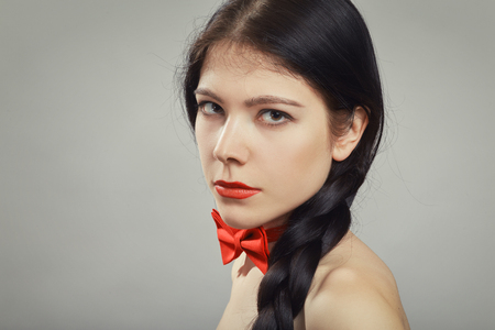 attractive girl with black plait on gray backgroundの写真素材