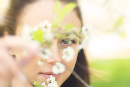sensual young woman in cherry flowers, blurred imageの写真素材