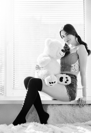 happy girl sitting with teddy bear, monochrome imageの写真素材