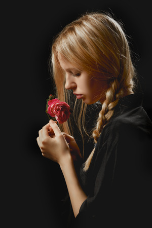 sensual blond girl with rose on black backgroundの写真素材