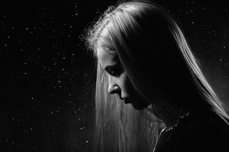 sad pensive girl profile on stars sky background, monochrome imageの写真素材