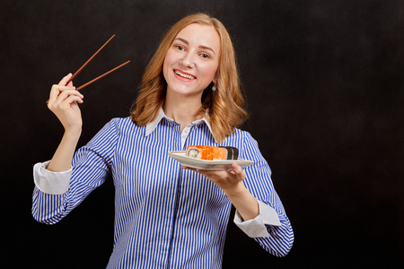 happy young woman with sushi looking at cameraの写真素材