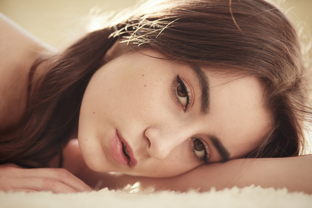 sensual girl lying looking at camera, toned imageの写真素材