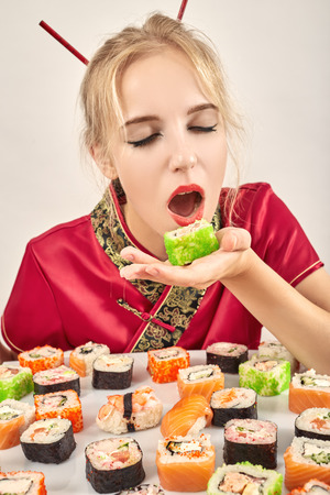 fun girl in the Japanese dress eats sushiの写真素材