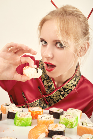 fun girl in the Japanese dress eats sushiの写真素材