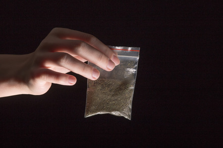 hand with pack of maijuana on black backgroundの写真素材