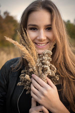 happy girl with autumn bouquet smiling, toned imageの写真素材