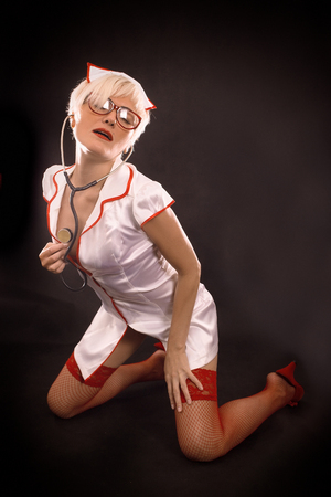 Sexy nurse with stethoscope listening her heartの写真素材