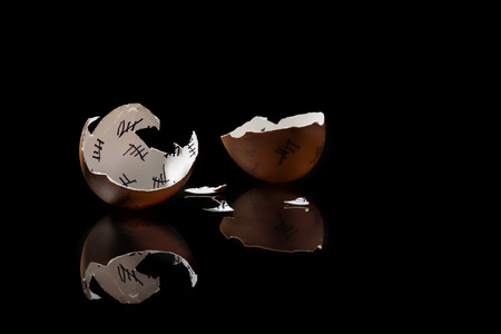 cracked egg shell with countdown on black background, monochromeの写真素材