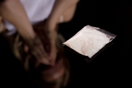 narcotic pack on black background with blurred female reflectionの写真素材