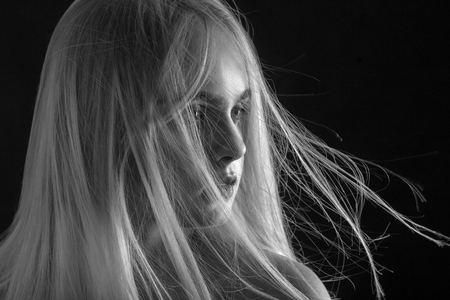 beautiful girl portrait with flying blond hair monochromeの写真素材