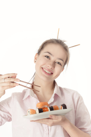 young woman with sushi smiling on white backgroundの写真素材