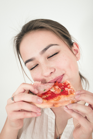 happy woman eats pizza isolated on white backgroundの写真素材
