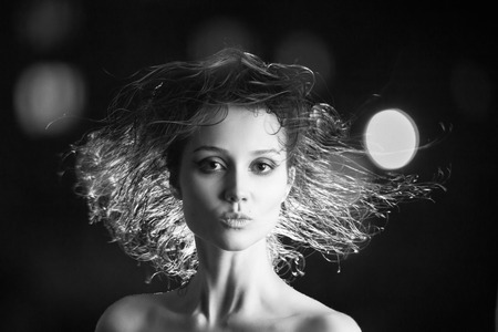 beautiful woman with flying wet hair on black background, monochromeの写真素材