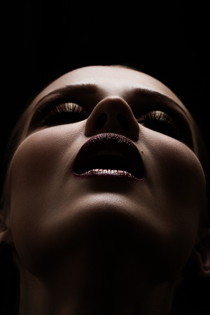 luxury beautiful female face with professional makeup on black backgroundの写真素材