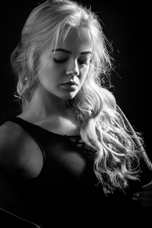 beautiful young blond female portrait on black background, monochromeの写真素材