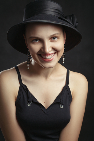 beautiful happy young woman in hat on black backgroundの写真素材