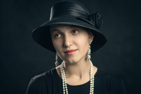 beautiful sensual young woman in hat on black backgroundの写真素材