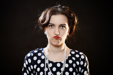 shocked girl on black background looking at cameraの写真素材