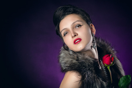 beautiful female retro style portrait with rose on purple background with copy space