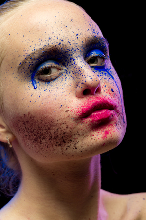female portrait with creative multicolored makeup on black backgroundの写真素材