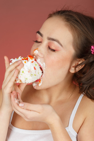 fun pretty girl with sweet dessert on red backgroundの写真素材