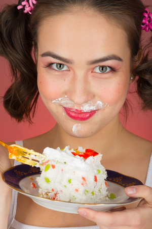 fun pretty girl with sweet dessert on red backgroundの写真素材