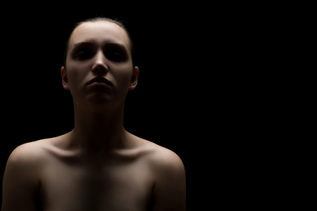 sad pensive woman on black background, image with copy spaceの写真素材