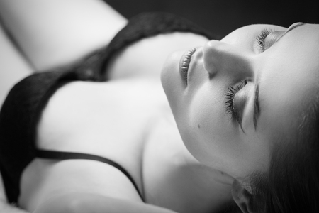 sensual woman relax with closed eyes on fur background, monochromeの写真素材