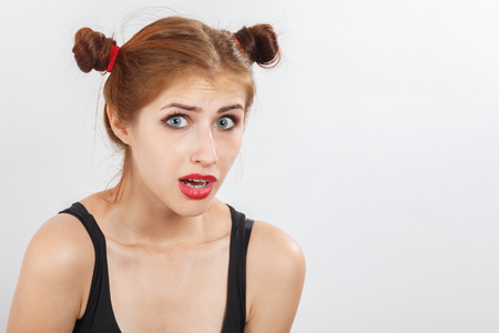 Shocked sad girl on white background looking at cameraの写真素材