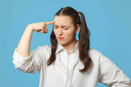sly girl thinker on blue background with finger oh her headの写真素材